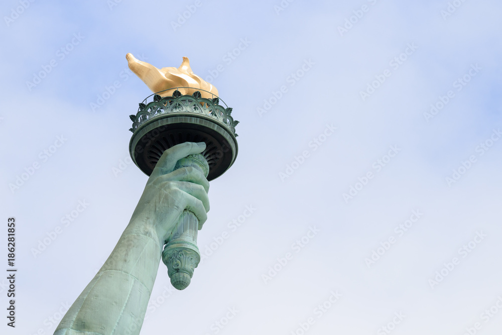 Close up of torch of the Statue of Liberty in New York City. This is the copper statue which is a gift from the people of France to the people of the United States. It’s a famous attraction in US. - obrazy, fototapety, plakaty 