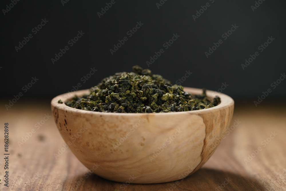dry organic green oolong tea in wood bowl dry organic green oolong tea in wood bowl