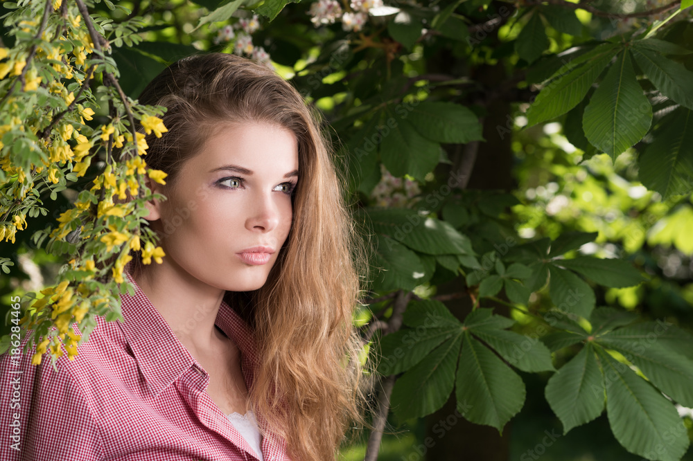 Horizontal portrait of a young woman with her hair beneath a flowered tree Horizontal portrait of a young woman with her hair beneath a flowered tree