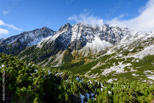 slovakian carpathian mountains in autumn. green hills with tops covered in first snow and white clouds above