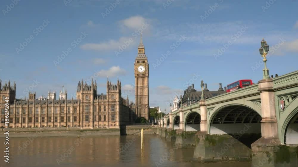 a morning panning shot of big ben and a red double decker bus in london, england a morning panning shot of big ben and a red double decker bus in london, england