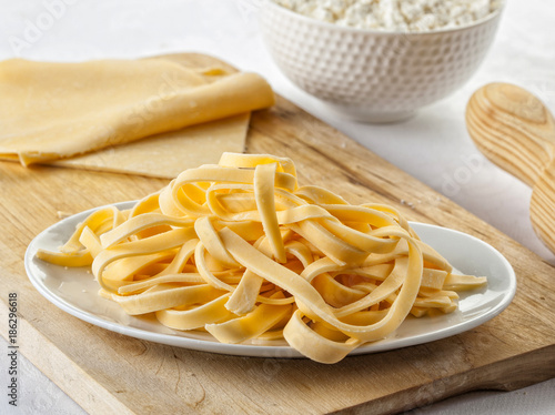 Cutting board with homemade tagliatelle pasta