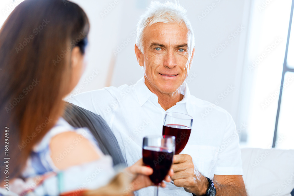 Senior man with holding a glass of wine indoors Senior man with holding a glass of wine indoors