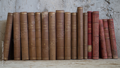 libri antichi vintage appoggiati a muro grezzo