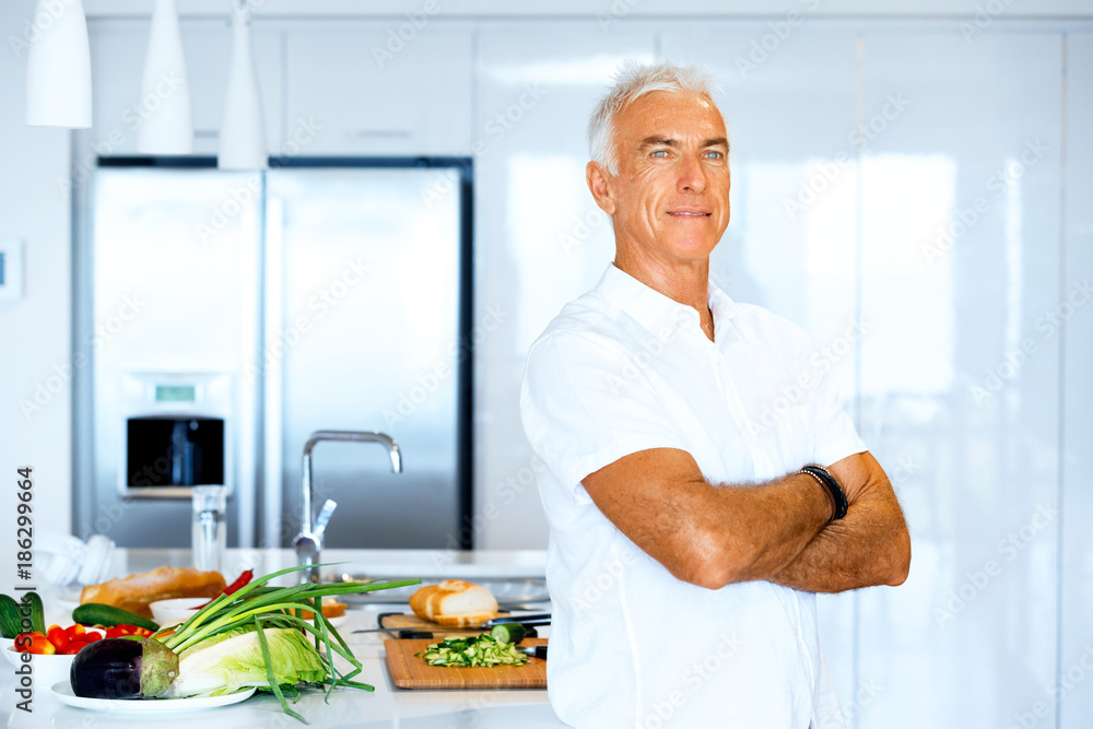 Portrait of a smart senior man standing in kitchen Portrait of a smart senior man standing in kitchen