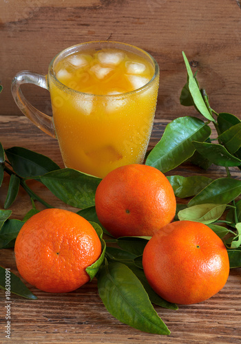 The mandarins and tangerine juice on a wooden background