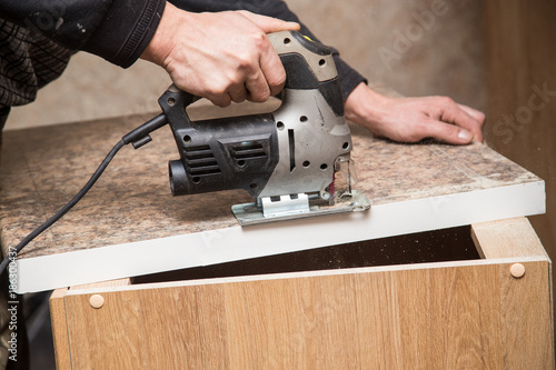 Master cuts wood with a jig saw