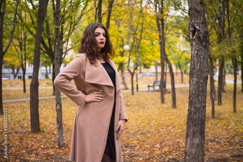 curly-haired girl in a beige coat