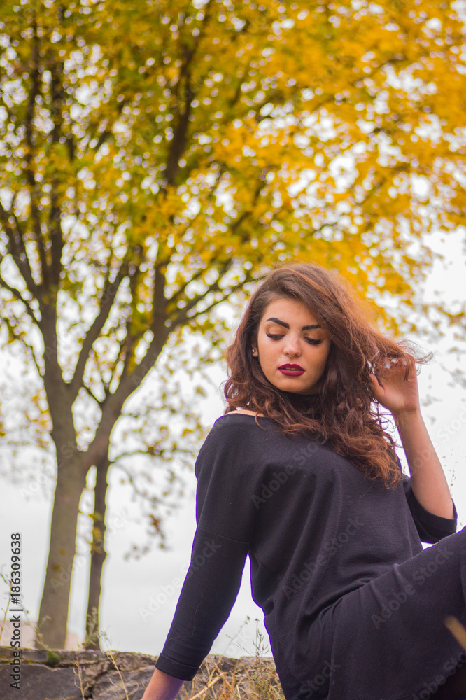 curly-haired girl in a beige coat curly-haired girl in a beige coat