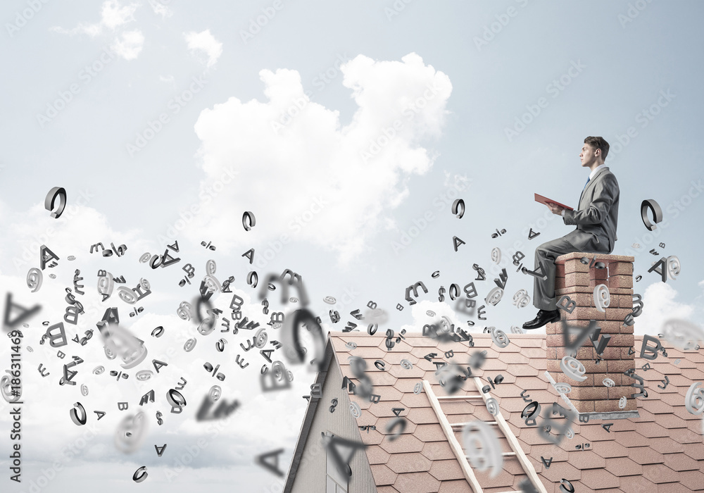 Man on brick roof reading book and symbols flying around Man on brick roof reading book and symbols flying around