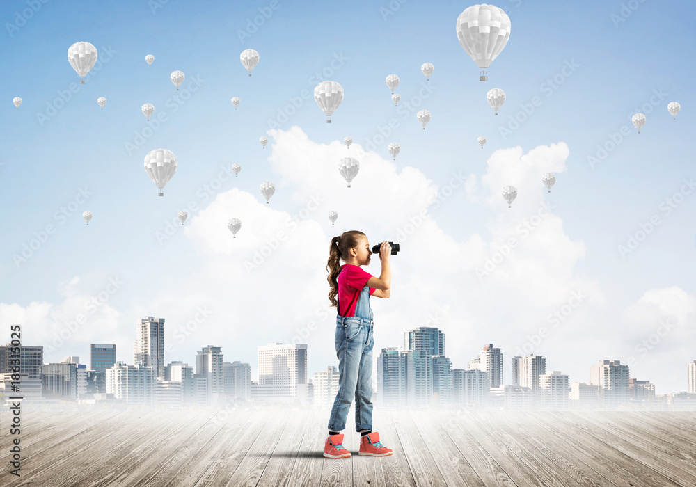 Concept of careless happy childhood with girl looking in binoculars Concept of careless happy childhood with girl looking in binoculars