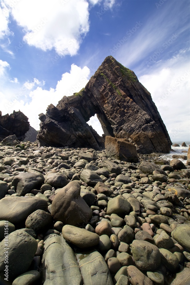 Rock arch formation on stoney beach in Cornwall, England.