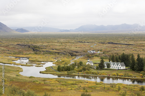 A view across fields to a river and buildings in Iceland photo