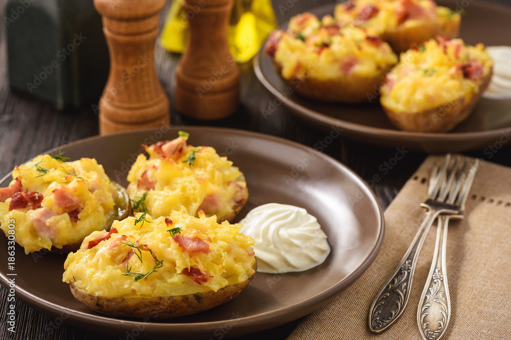 Ham and cheese jacket potatoes on dark background.