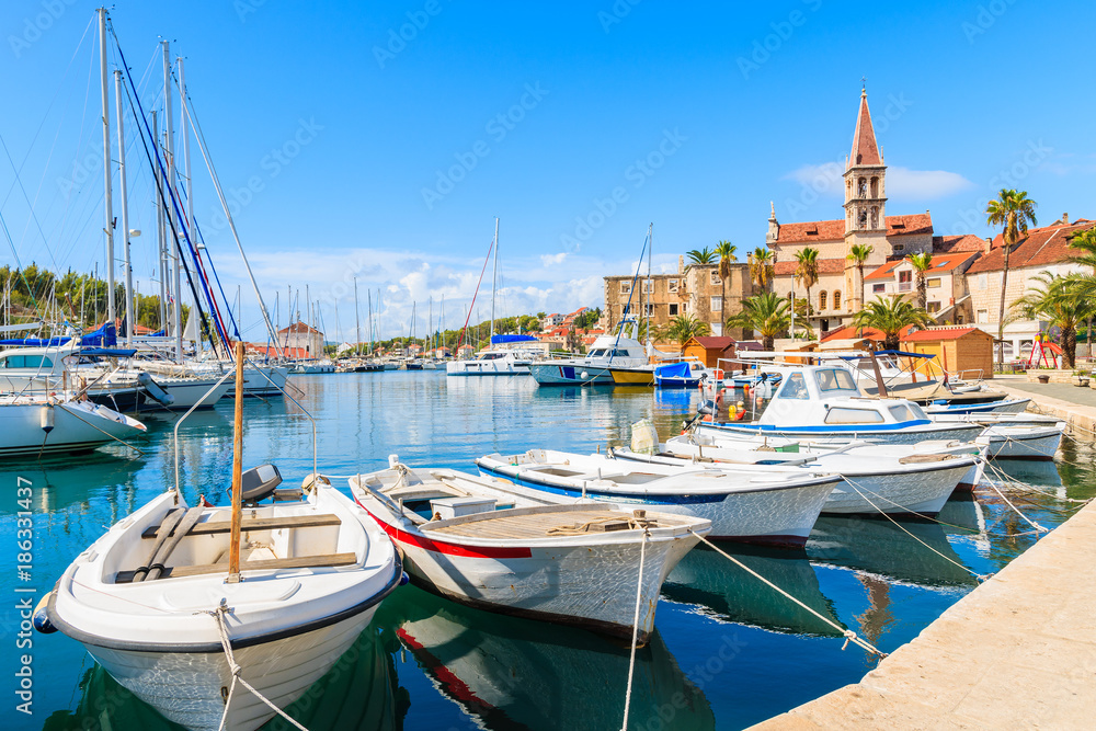 Fishing boats and view of beautiful church in Milna port on sunny summer day, Brac island, Croatia