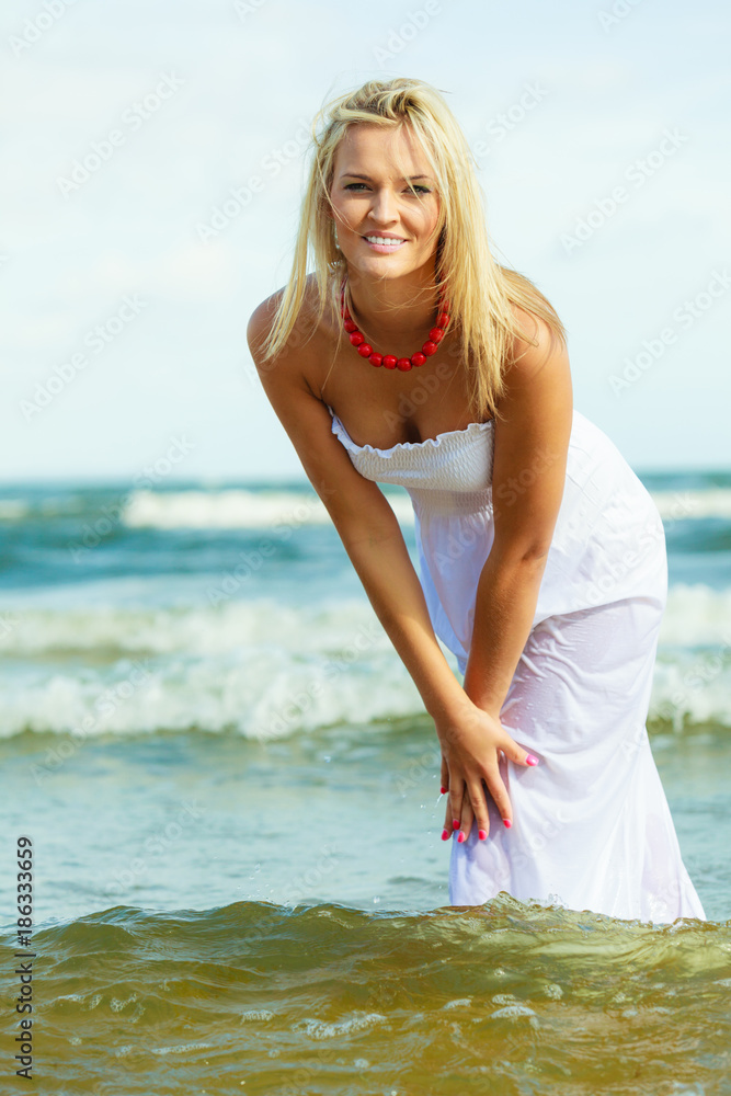 Blonde woman wearing dress playing with water Blonde woman wearing dress playing with water