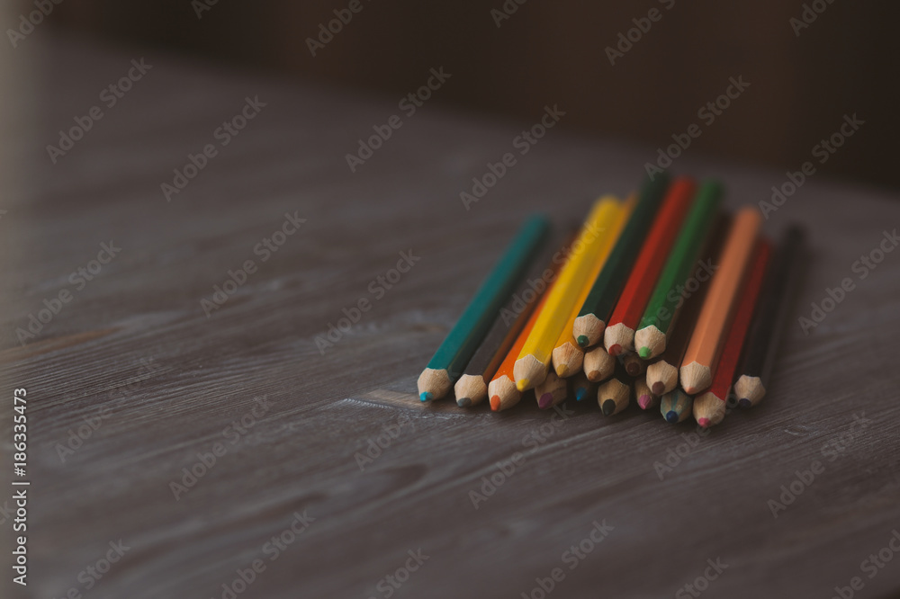 colored pencils on a dark wooden background colored pencils on a dark wooden background