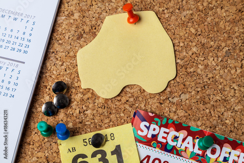 Blank car shaped Note on cork notice board with red pin photo