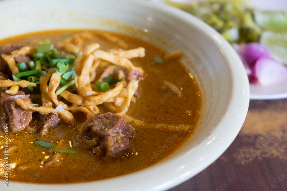 Egg Noodle in beef with curry and crispy noodle on top (Kao Soi), Traditional Chiangmai thai cuisine made of fresh ingredients. Egg Noodle in beef with curry and crispy noodle on top (Kao Soi), Traditional Chiangmai thai cuisine made of fresh ingredients.