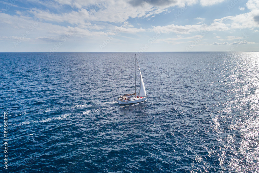 Naklejka premium Aerial view on a white yacht under a white sail. Montenegro.