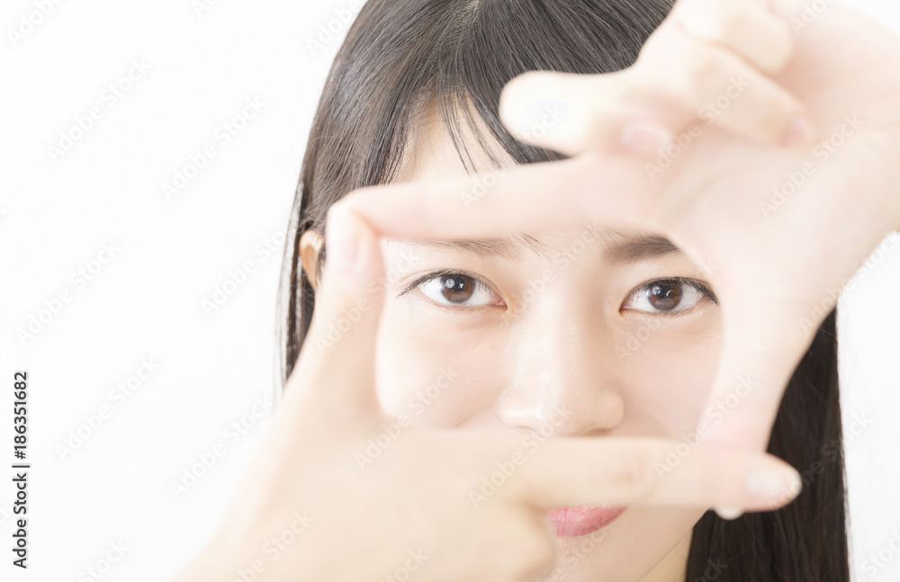 Fototapeta premium 若い女性 トリミング ポーズ 指で構図 フレーミングをとる カメラ目線