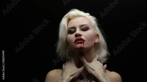 Male hands strangle blonde. Male hands on neck of woman. Halloween theme, shallow depth of field
