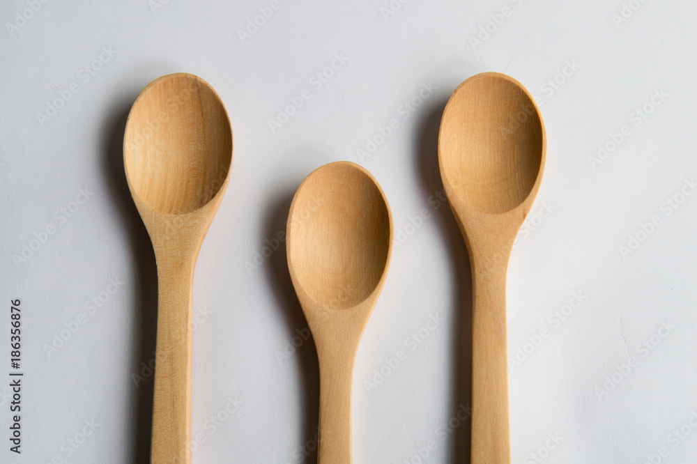 Three teaspoons of natural wood. Isolated on white background. Three teaspoons of natural wood. Isolated on white background.