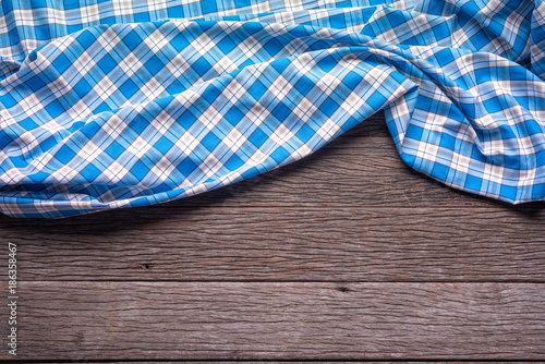 Blue Checkered Fabric on wood Background.
