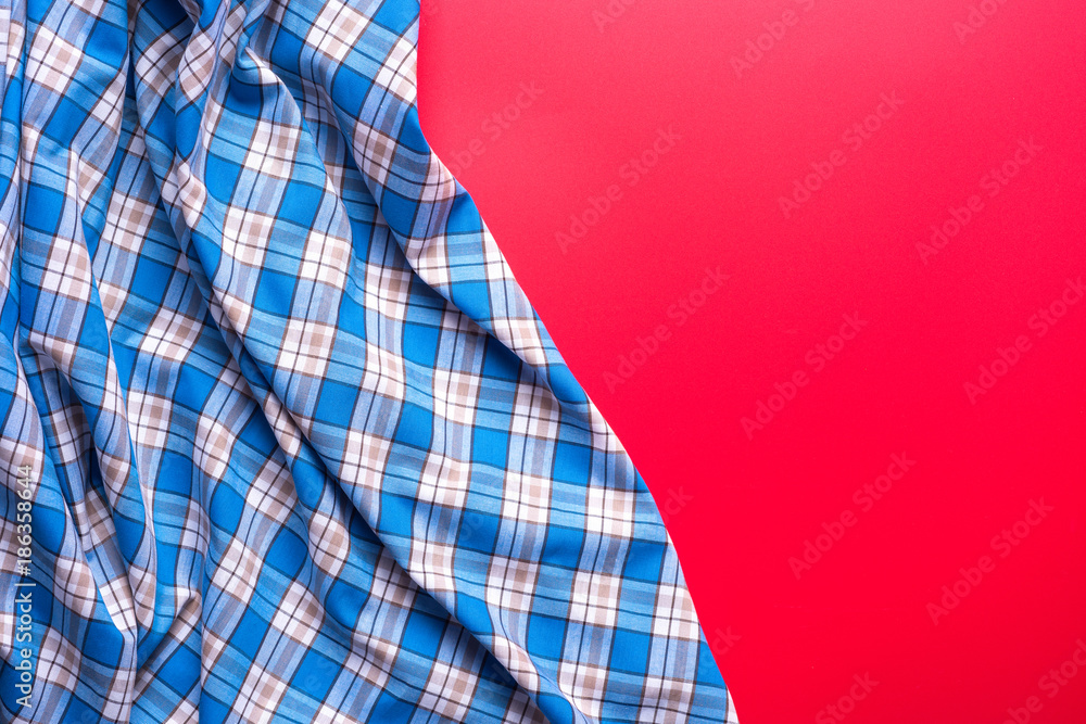 Blue Checkered Fabric on red Background. Blue Checkered Fabric on red Background.