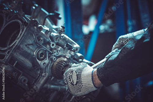 The auto mechanic dismantles the opposing engine.