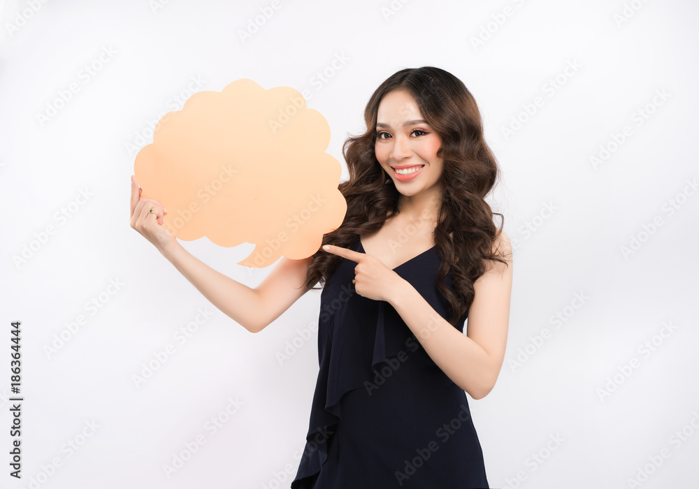 Cheerful attractive young woman standing and holding blank speech bubble Cheerful attractive young woman standing and holding blank speech bubble