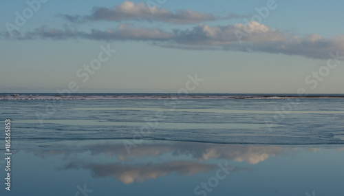 Clouds reflected in sea at low tide Iceland in winter © sue