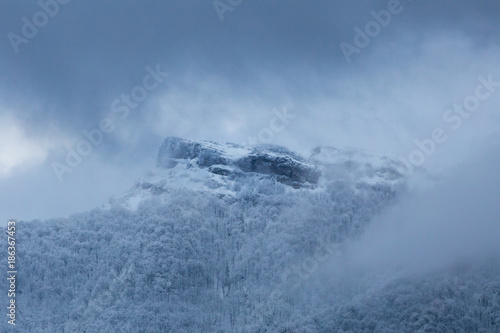 Fototapeta Naklejka Na Ścianę i Meble -  Dramatic winter mountain scenery at Slovakia, Mala Fatra, Klak. Snow storm closing in on frozen forests and hiding Klak peak to cold winter mist.