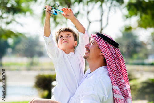 Arabic father and little kid play outdoors.