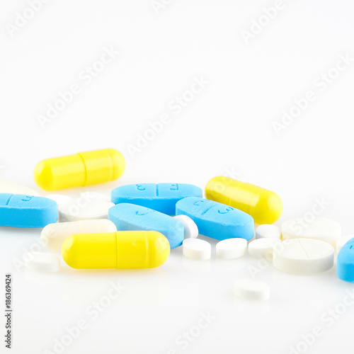 Assorted pharmaceutical medicine pills, tablets and capsules on white background