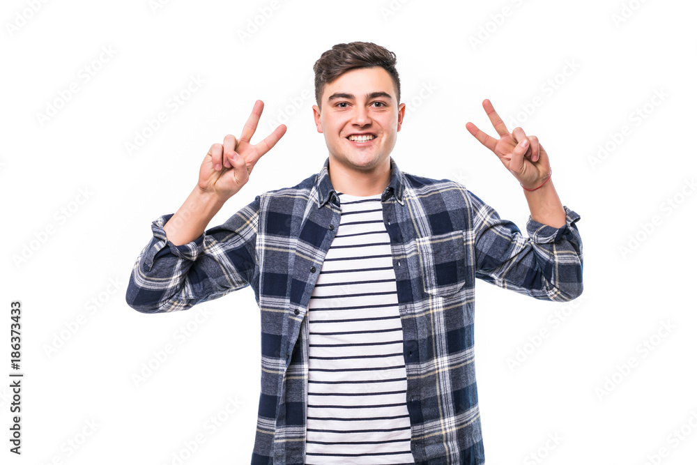 young man posing in white isolated studio background with hand in pocket while showing the victory sign and looking at the camera young man posing in white isolated studio background with hand in pocket while showing the victory sign and looking at the camera