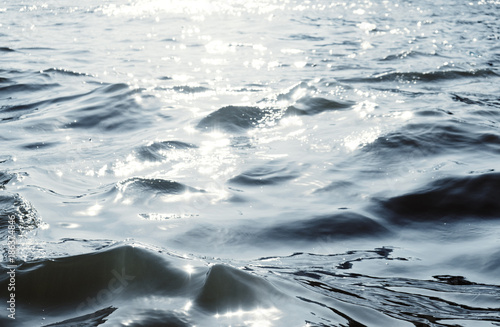 Water surface with ripples and sunlight reflections