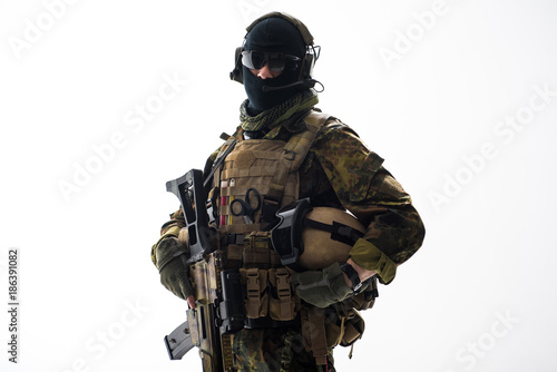 Portrait of calm soldier speaking by headset while holding helmet in arms. Army and conversation concept. Isolated