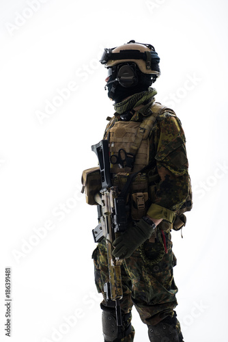 Side view serious soldier telling by microphone while holding modern weapon in hands. Army concept. Isolated