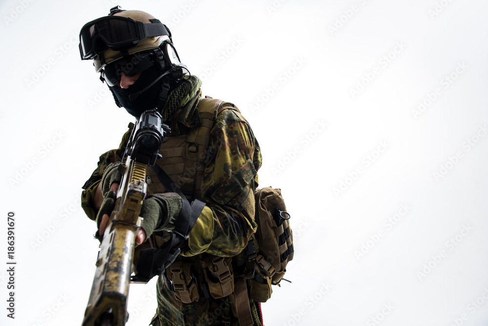 Portrait of severe soldier holding modern weapon in hands. He looking at camera. Attack concept. Isolated and copy space Portrait of severe soldier holding modern weapon in hands. He looking at camera. Attack concept. Isolated and copy space