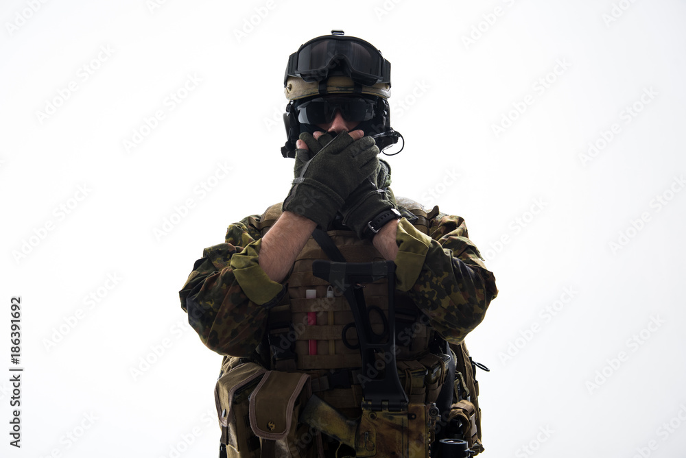 Fototapeta premium Portrait of serious soldier closing mouth by hands while wearing military uniform. Confidence concept. Isolated