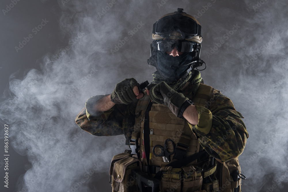Portrait of orderly peacemaker pulling out joint pin from grenade. War concept Portrait of orderly peacemaker pulling out joint pin from grenade. War concept