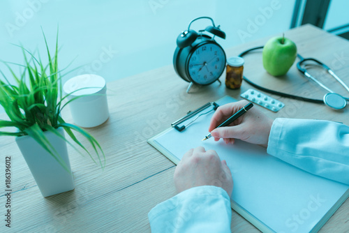 General practitioner writing notes during medical exam photo