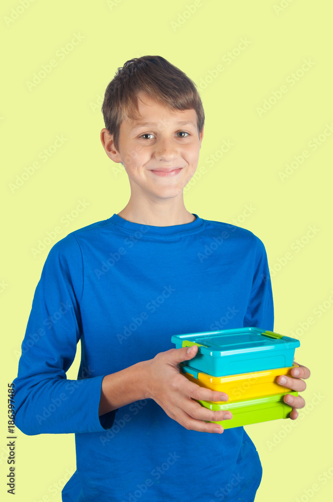 Boy holding healthy lunchbox. isolated on yellow background Boy holding healthy lunchbox. isolated on yellow background