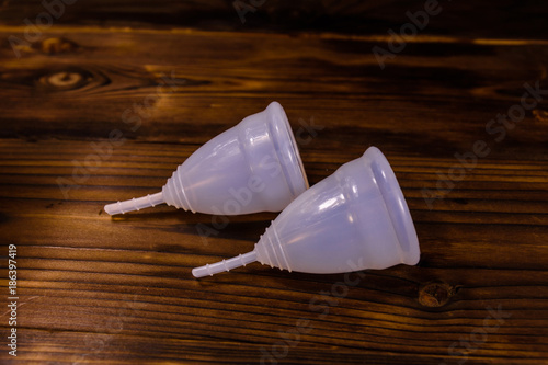 Two menstrual cups on a wooden table
