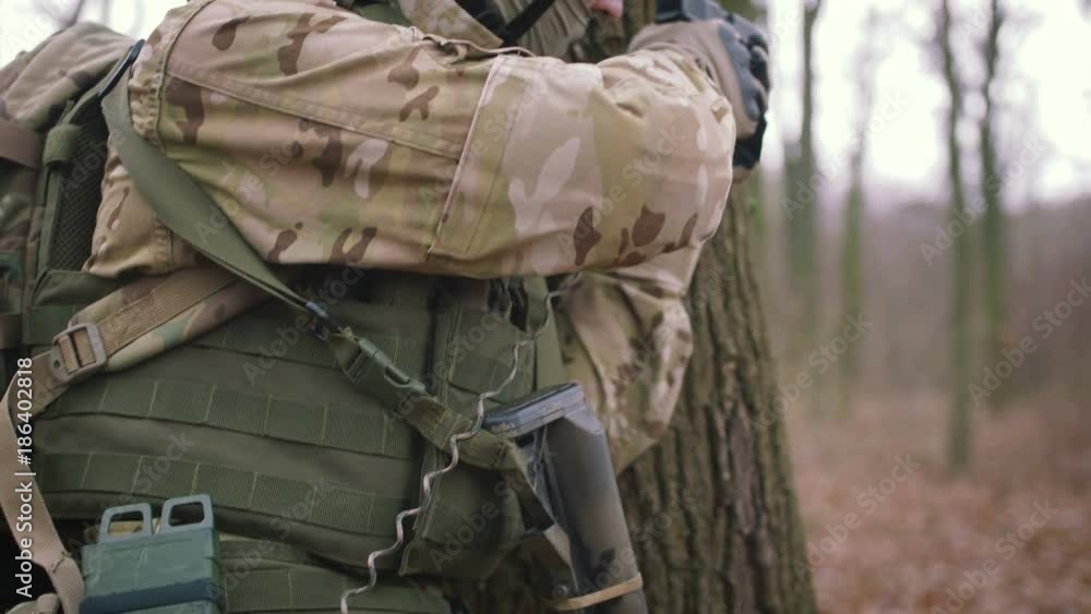Armed young man in a zone of armed conflict in uniform targeting with pistol in forest, slow motion. Airsoft Armed young man in a zone of armed conflict in uniform targeting with pistol in forest, slow motion. Airsoft