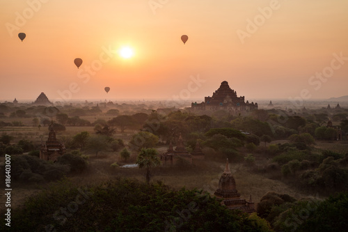 Silhouette of many ancient temples and pagodas and four hot-air balloons over plain of Bagan in Myanmar  Burma  at sunrise.