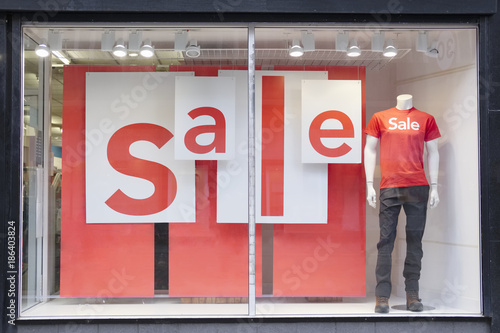 Sale sign in shop mall window and mannequin
