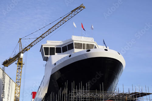 Shipbuilding construction in progress with tower crane blue sky port harbor harbour greenock glasgow Scotland uk photo