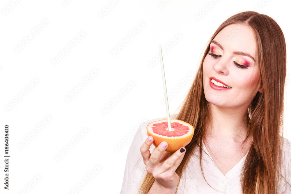 Woman holds grapefruit drinking juice from fruit Woman holds grapefruit drinking juice from fruit